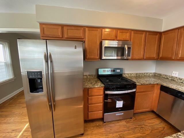 17843 Roy Street Lansing, IL 60438 - Photo 4 of 19 a kitchen with granite countertop stainless steel appliances and wooden cabinets