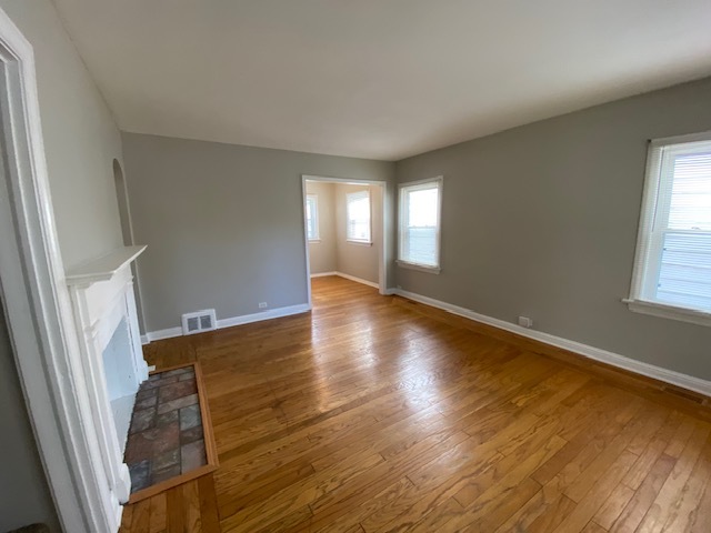 17843 Roy Street Lansing, IL 60438 - Photo 7 of 19 an empty room with wooden floor and windows
