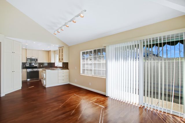 a view of a kitchen with a sink and dishwasher a oven with wooden floor