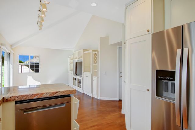 a kitchen with stainless steel appliances granite countertop a refrigerator and a stove