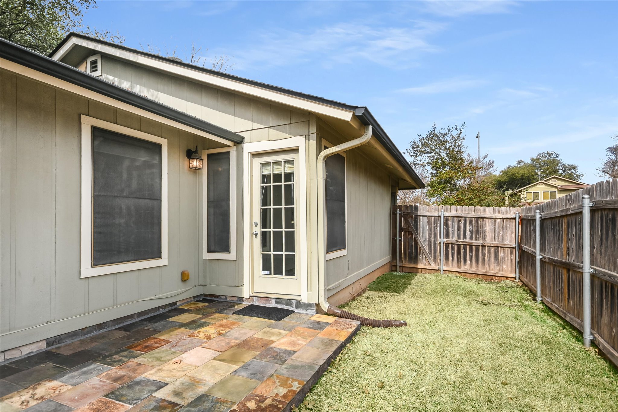 7701 Grovedale Trail Austin, TX 78729 - Photo 13 of 13 View of side of home with a fenced backyard and a patio