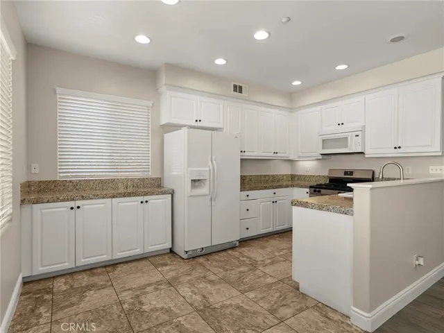 a kitchen with refrigerator and cabinets