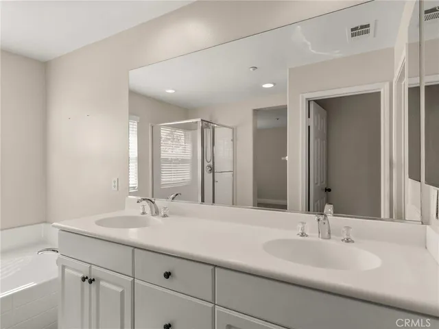 a bathroom with double vanity sinks and a mirror