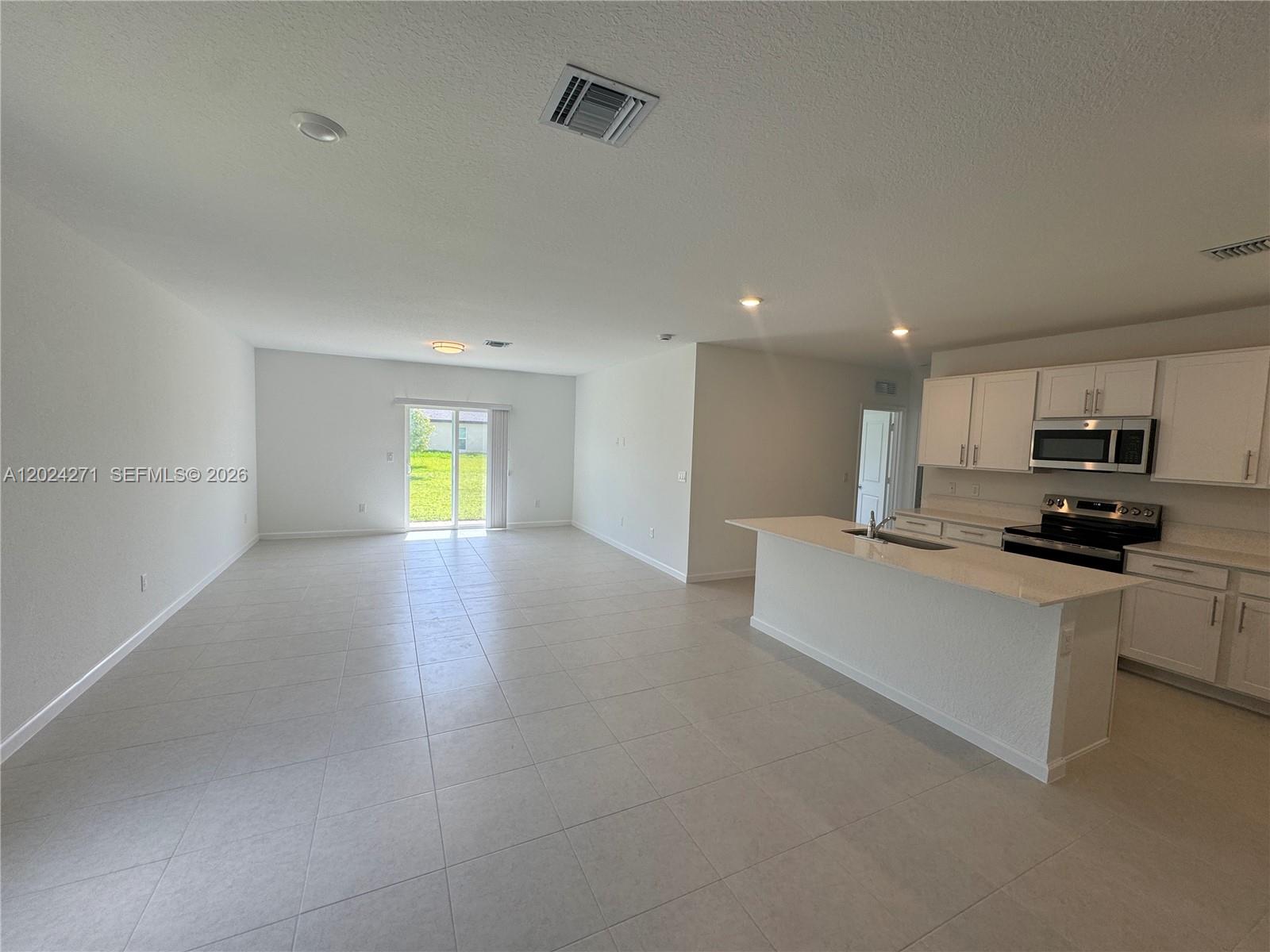 693 Carlyle Way Fort Pierce, FL 34947 - Photo 3 of 19 a view of kitchen with microwave a refrigerator and a sink