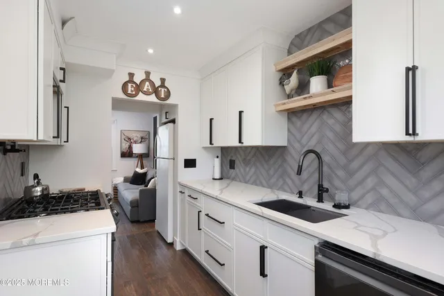 a kitchen with a sink a stove and cabinets