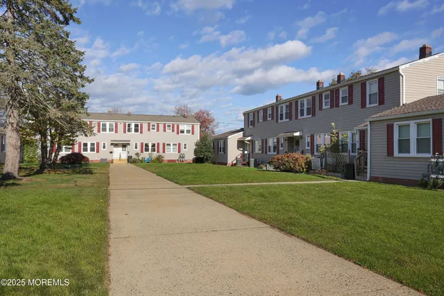 a view of a big building with a big yard and a large trees