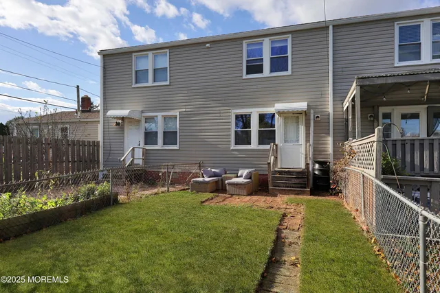 a view of a house with backyard and sitting area