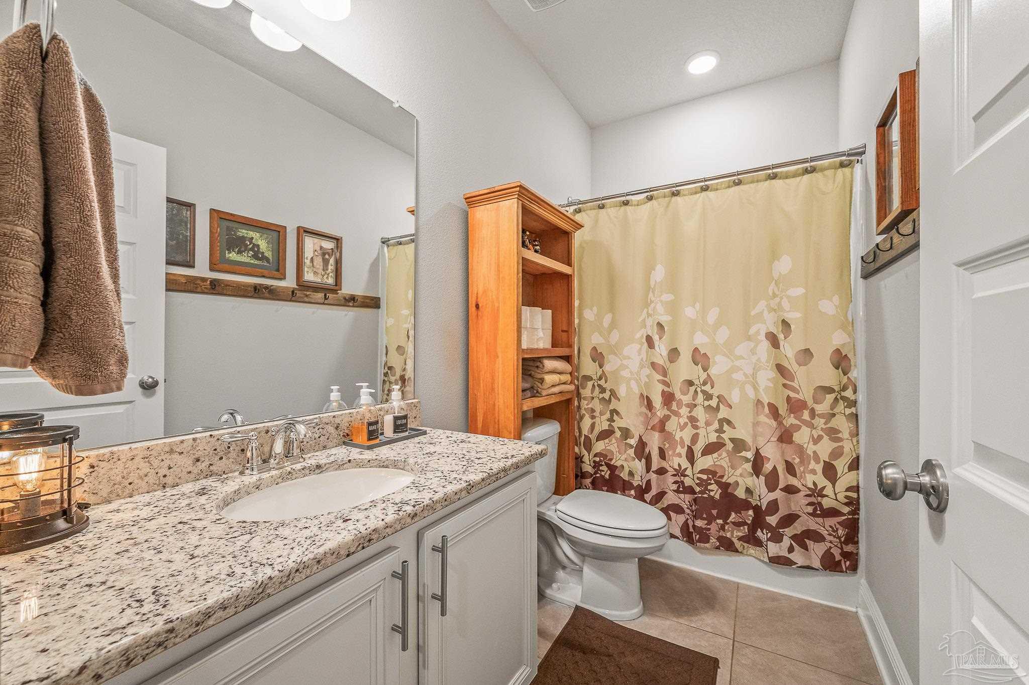 8056 Stream Ridge Road Pensacola, FL 32526 - Photo 19 of 71 a bathroom with a granite countertop sink toilet and shower