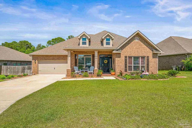 a front view of a house with yard porch and outdoor seating