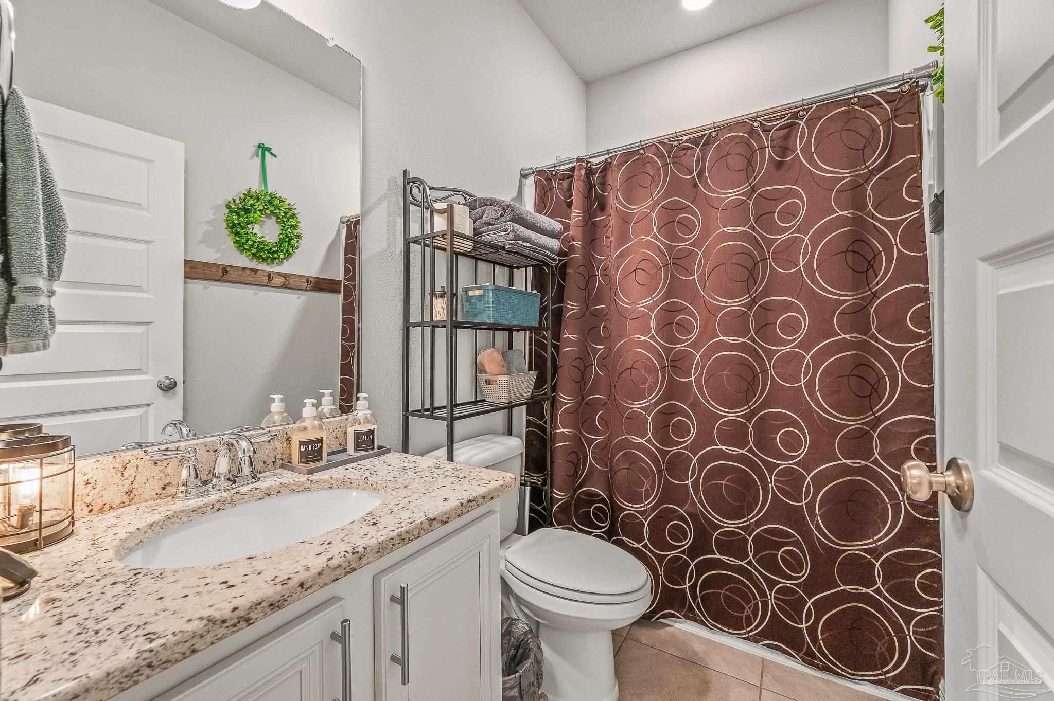 8056 Stream Ridge Road Pensacola, FL 32526 - Photo 26 of 71 a bathroom with a granite countertop toilet sink and mirror