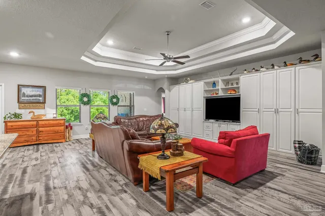 a view of a yard with plants and large trees