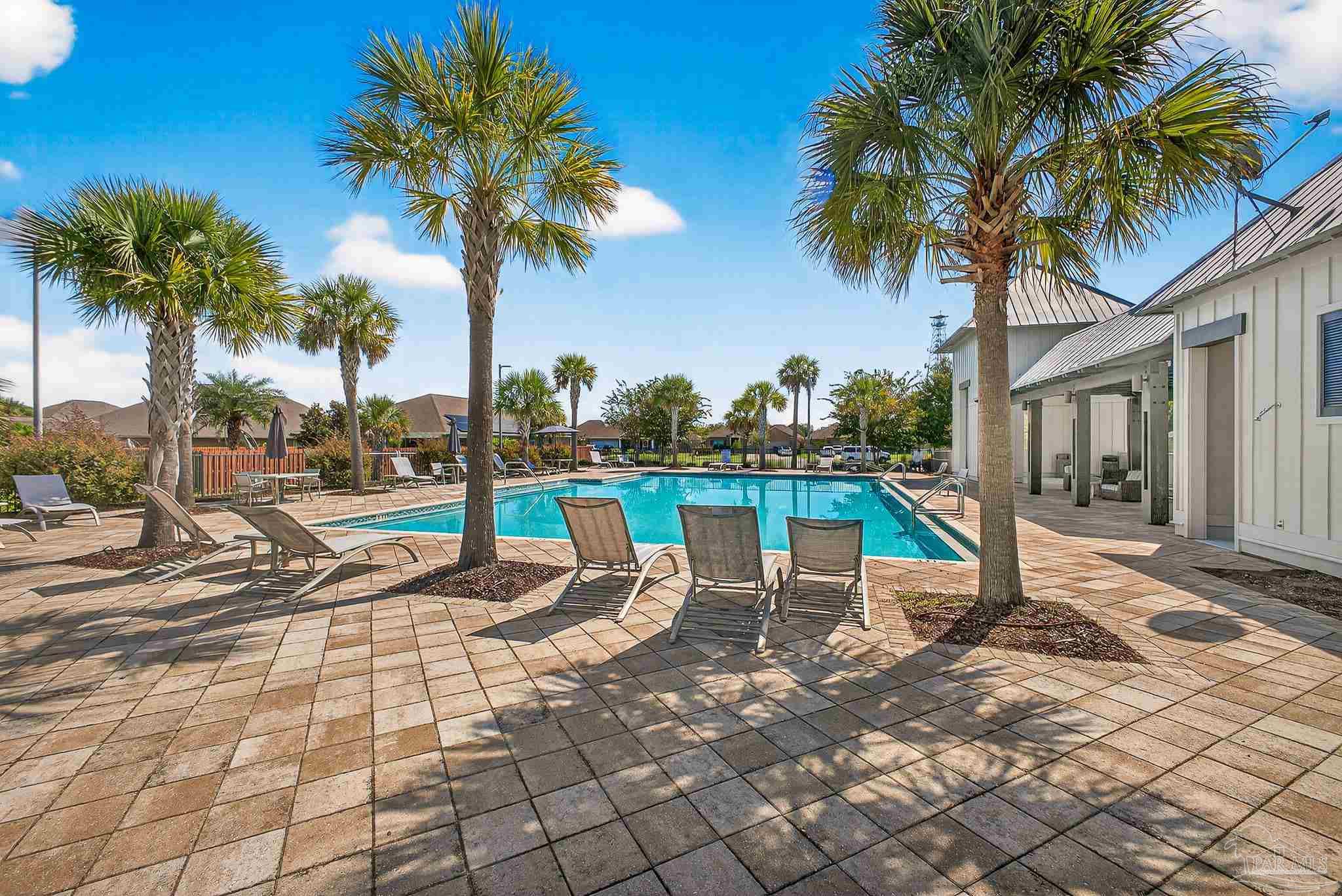 8056 Stream Ridge Road Pensacola, FL 32526 - Photo 57 of 71 a view of a swimming pool with a lounge chair and palm trees
