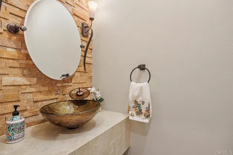 a bathroom with a granite countertop double vanity sink mirror and shower