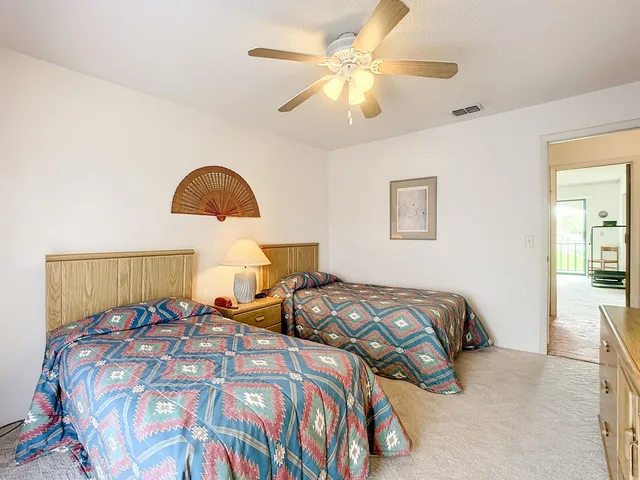a bedroom with two beds and a large window