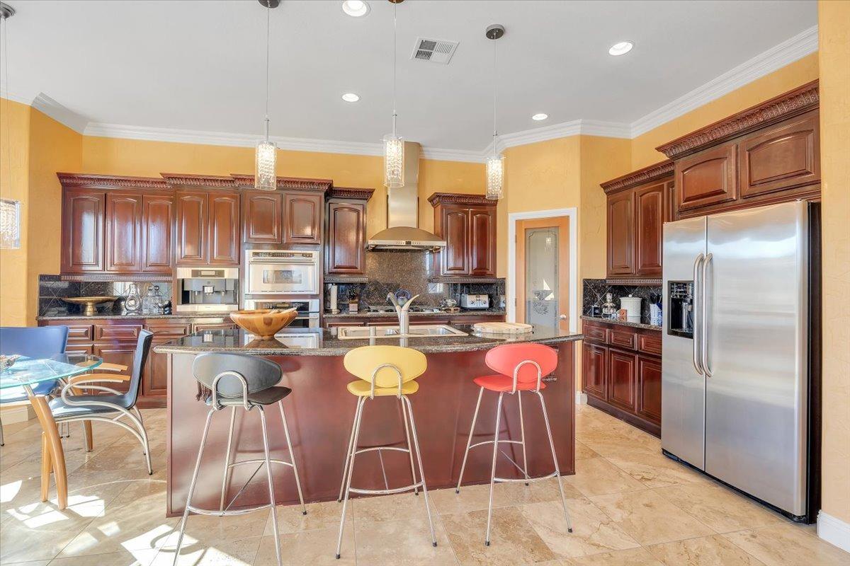 78 Aphrodite Court Copperopolis, CA 95228 - Photo 22 of 98 a kitchen with stainless steel appliances kitchen island granite countertop a refrigerator a stove top oven and a sink with island