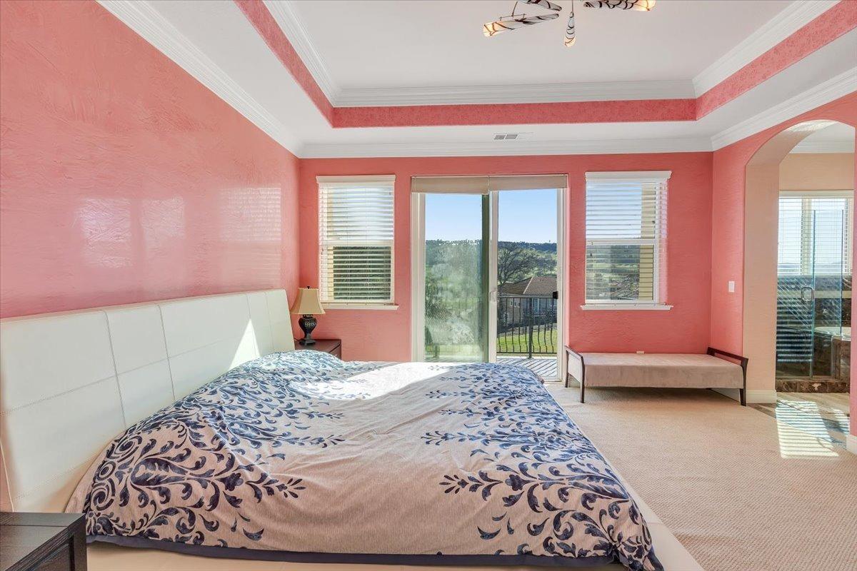 78 Aphrodite Court Copperopolis, CA 95228 - Photo 36 of 98 a bedroom with a large bed and a couch next to a window