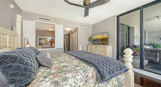 a bedroom with bed and a flat tv screen on dresser