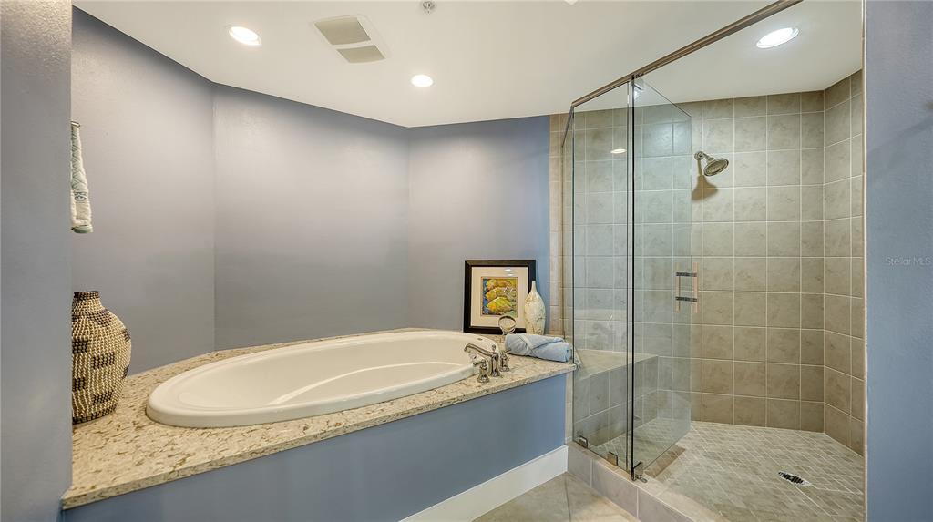 50 Central Avenue, Unit 14B Sarasota, FL 34236 - Photo 32 of 69 a bathroom with a granite countertop bathtub shower and a sink