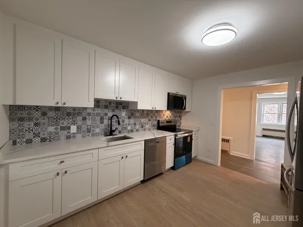 a kitchen with stainless steel appliances granite countertop a stove sink and cabinets