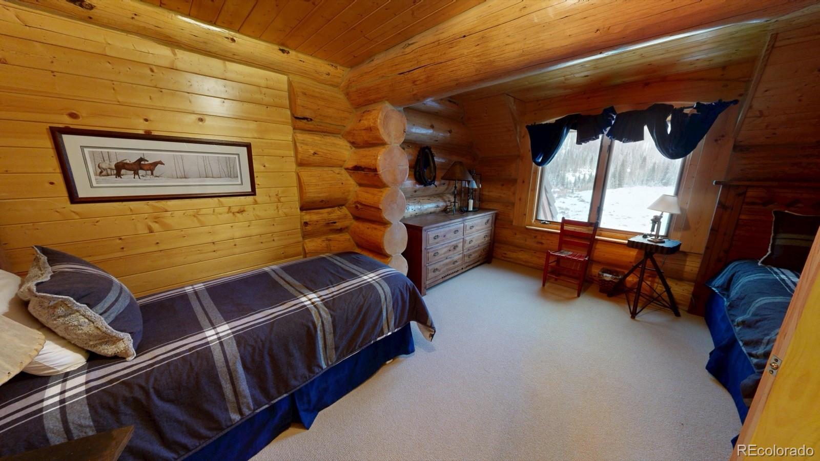 2418 Forest Road Creede, CO 81130 - Photo 12 of 50 a bed room with a bed chair and a window