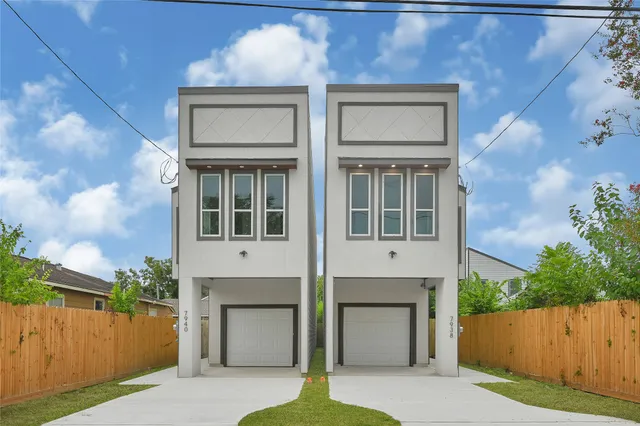 a front view of a house with a garden and garage