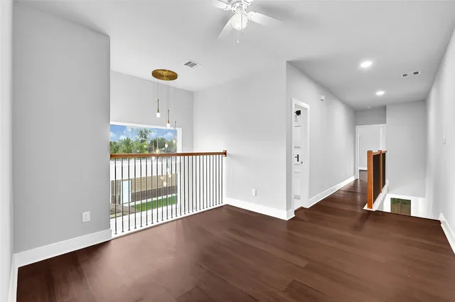 a view of a hallway with wooden floor