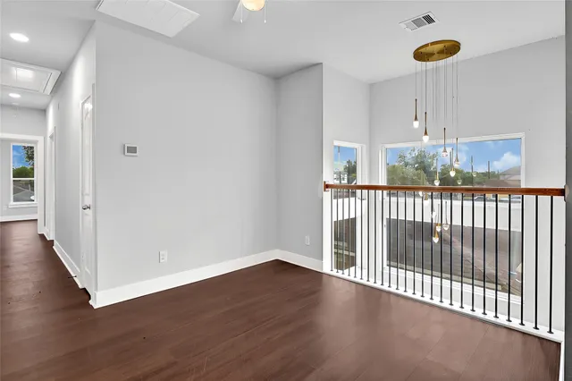 a view of a room with wooden floor windows and garden view