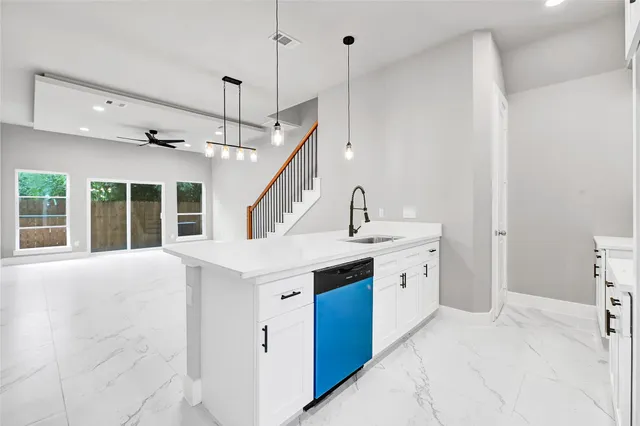 a large white kitchen with a stove sink and a refrigerator