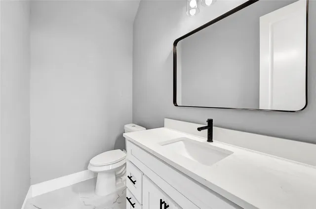 a bathroom with a sink a toilet and mirror