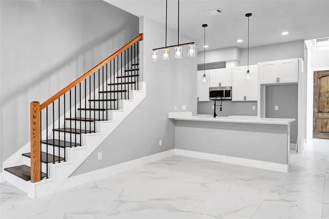 a view of kitchen with kitchen island sink and refrigerator