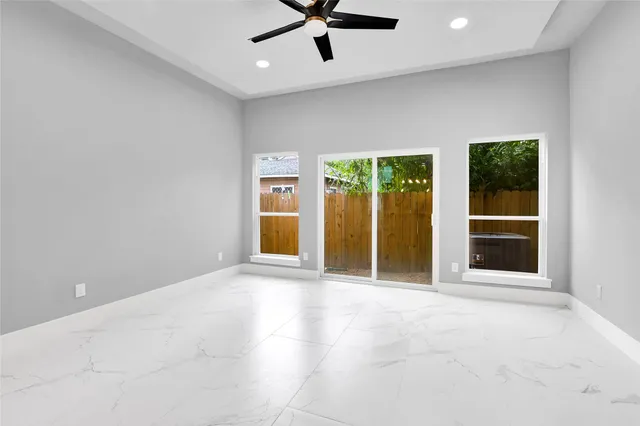 an empty room with window and a ceiling fan