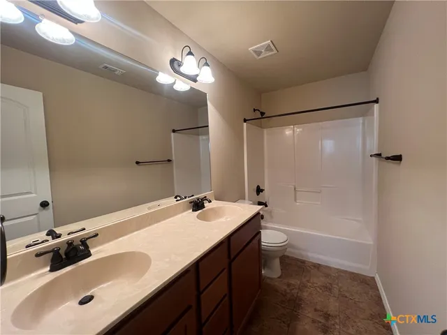 a bathroom with a sink a toilet a mirror a bathtub and shower