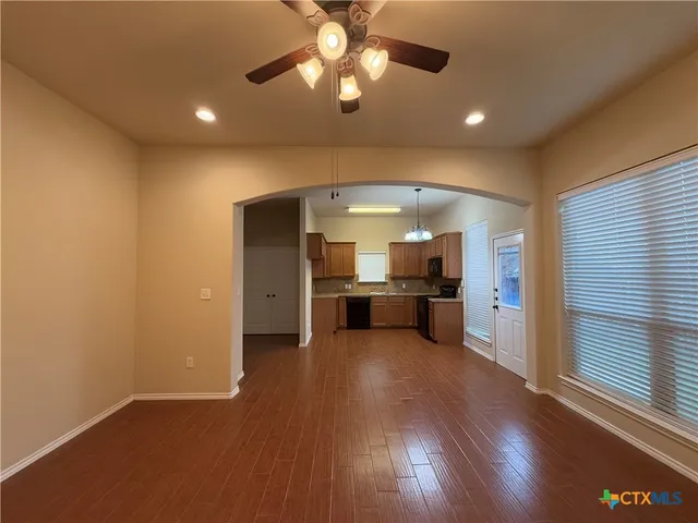a view of a kitchen with a sink and dishwasher a refrigerator with wooden floor