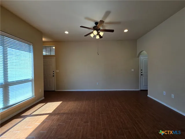a view of an empty room with glass door and a window