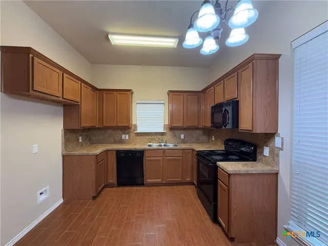 a kitchen with stainless steel appliances granite countertop a stove top oven a sink and dishwasher