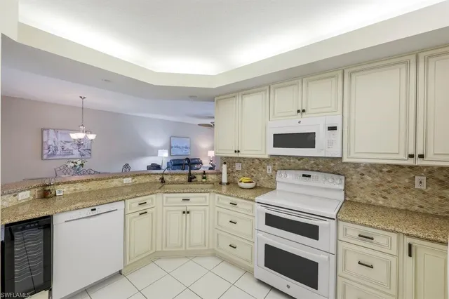 a kitchen with white cabinets sink and white appliances