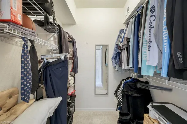a view of walk in closet with clothes and shoes
