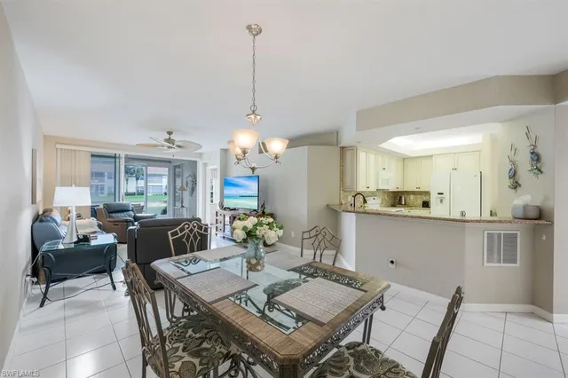 a view of a dining room and livingroom with furniture wooden floor a chandelier