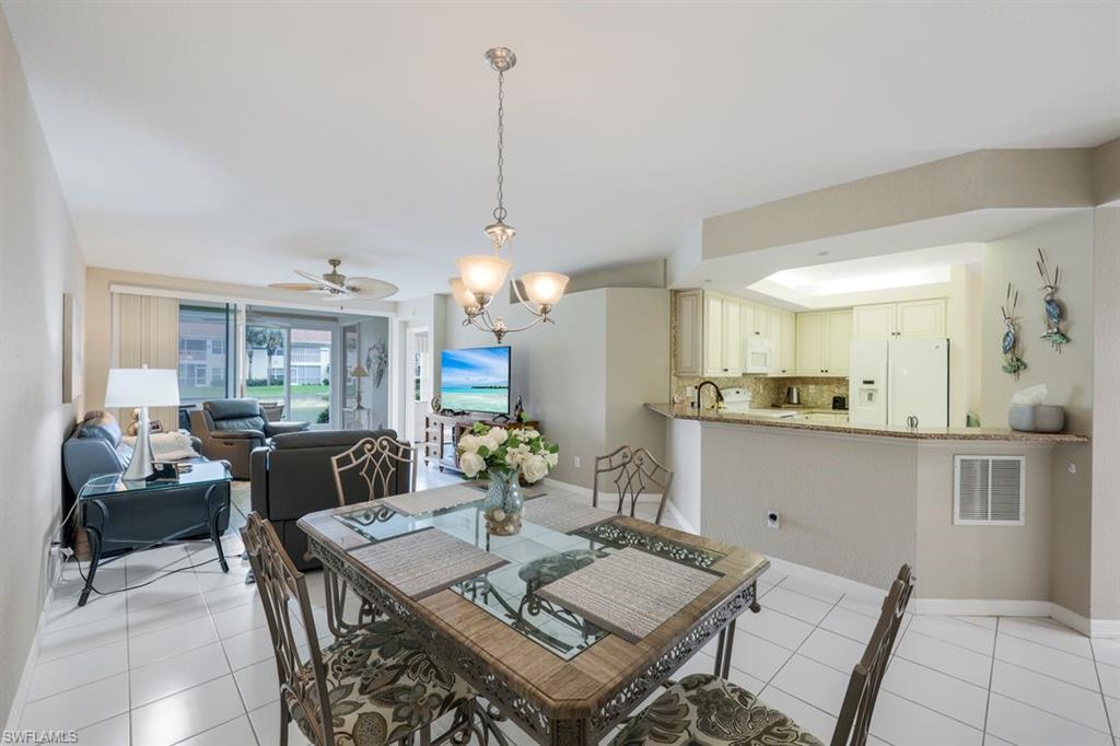 23730 Eddystone Road, Unit 5102 Bonita Springs, FL 34135 - Photo 16 of 24 a view of a dining room and livingroom with furniture wooden floor a chandelier