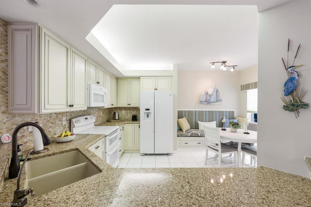 23730 Eddystone Road, Unit 5102 Bonita Springs, FL 34135 - Photo 17 of 24 a kitchen with stainless steel appliances kitchen island granite countertop a sink and cabinets