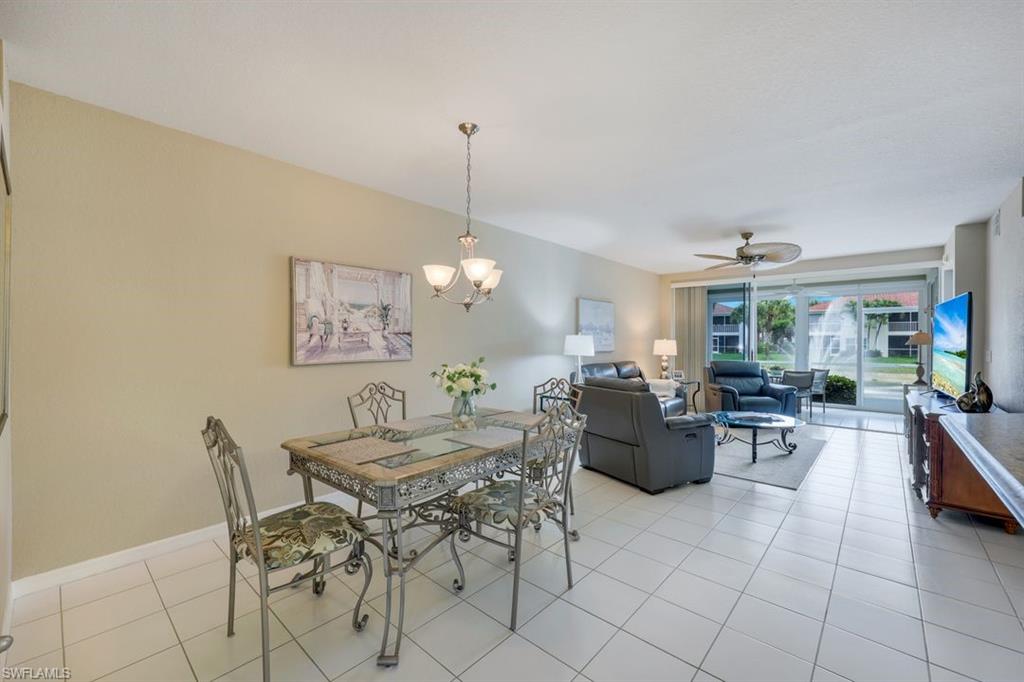 23730 Eddystone Road, Unit 5102 Bonita Springs, FL 34135 - Photo 19 of 24 a living room with furniture and a chandelier