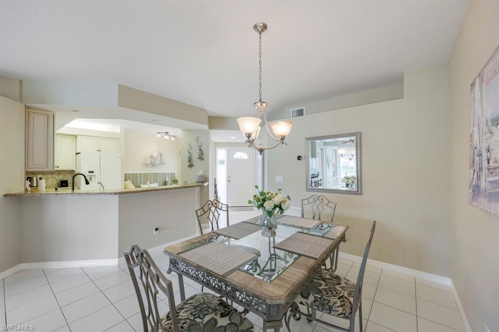23730 Eddystone Road, Unit 5102 Bonita Springs, FL 34135 - Photo 20 of 24 a view of a dining room with furniture and chandelier