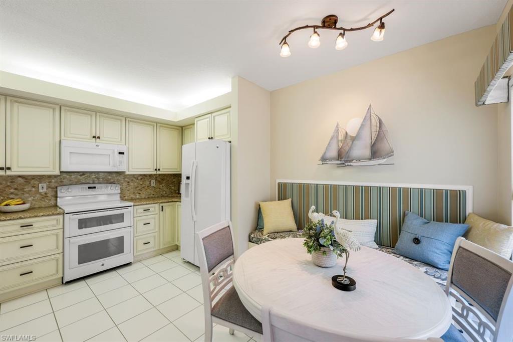 23730 Eddystone Road, Unit 5102 Bonita Springs, FL 34135 - Photo 24 of 24 a kitchen with stainless steel appliances kitchen island granite countertop a sink and cabinets