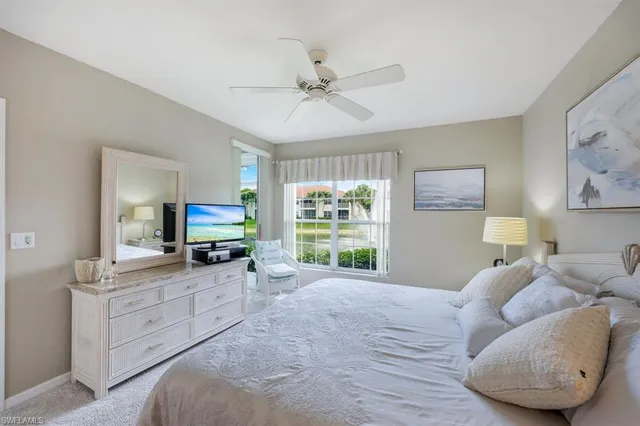 a large bedroom with a bed and a flat tv screen on dresser