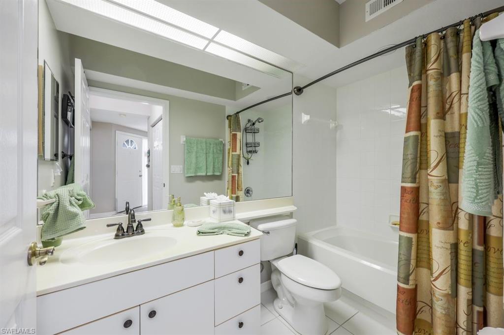 23730 Eddystone Road, Unit 5102 Bonita Springs, FL 34135 - Photo 8 of 24 a bathroom with a double vanity sink toilet mirror and shower