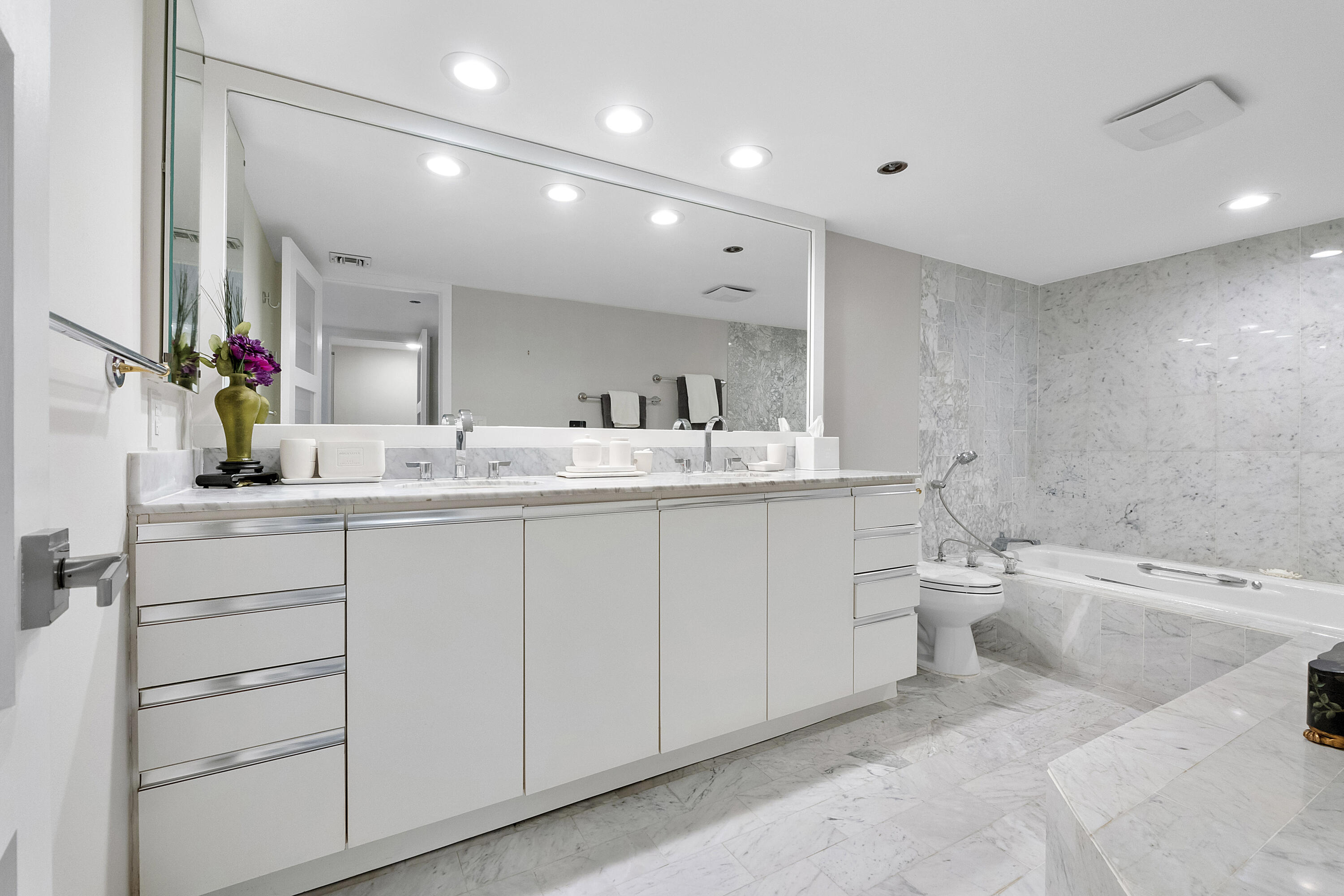 501 North Riverside Drive, Unit 203 Pompano Beach, FL 33062 - Photo 17 of 35 a bathroom with a double vanity sink a toilet and a mirror