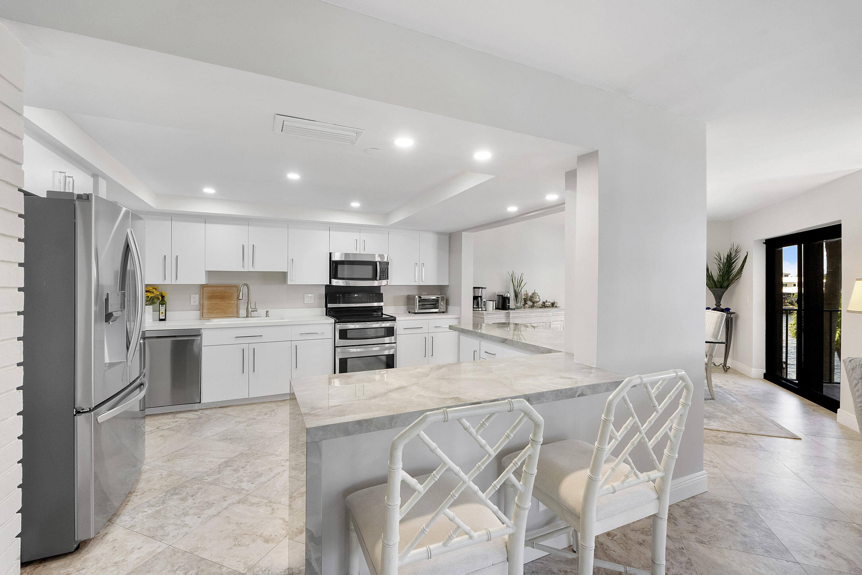 501 North Riverside Drive, Unit 203 Pompano Beach, FL 33062 - Photo 5 of 35 a kitchen with stainless steel appliances kitchen island granite countertop a refrigerator and a stove top oven