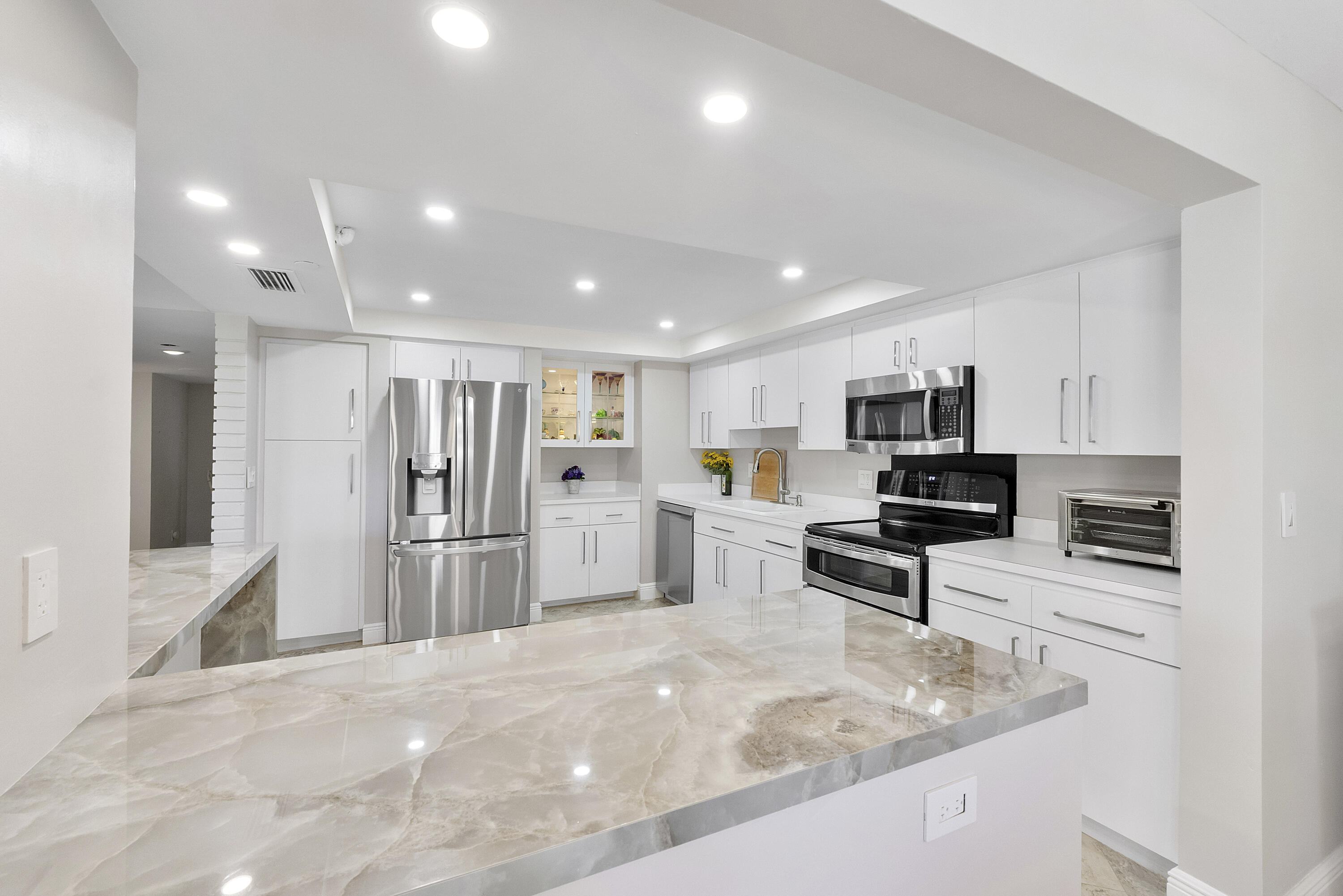501 North Riverside Drive, Unit 203 Pompano Beach, FL 33062 - Photo 6 of 35 a kitchen with stainless steel appliances granite countertop a refrigerator stove microwave and sink