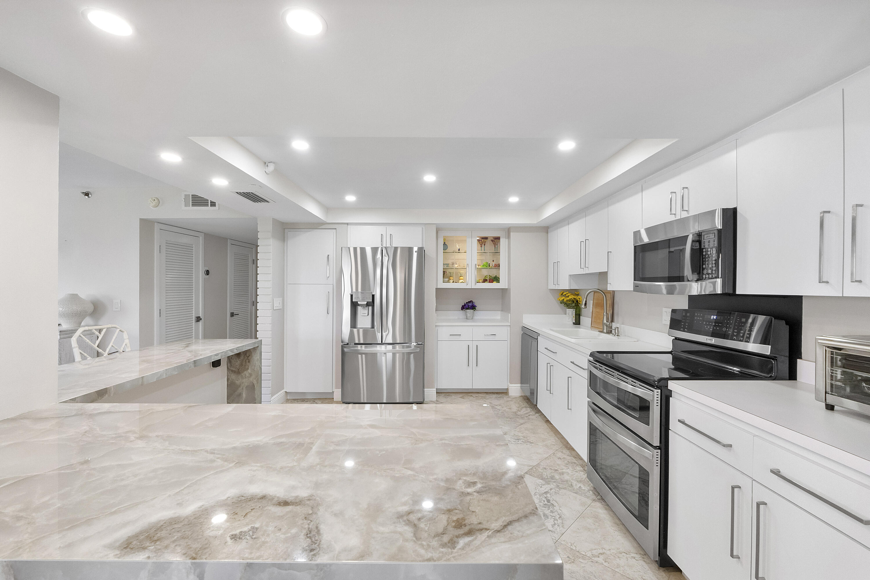 501 North Riverside Drive, Unit 203 Pompano Beach, FL 33062 - Photo 7 of 35 a large kitchen with stainless steel appliances kitchen island granite countertop a refrigerator and a stove top oven