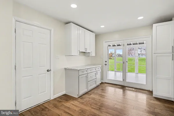 a view of empty room with wooden floor and window